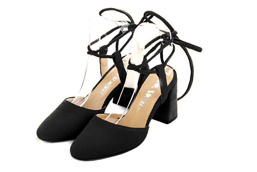 Matt black elegant closed-toe heels, with crossed straps. Round toe. High flare heels.